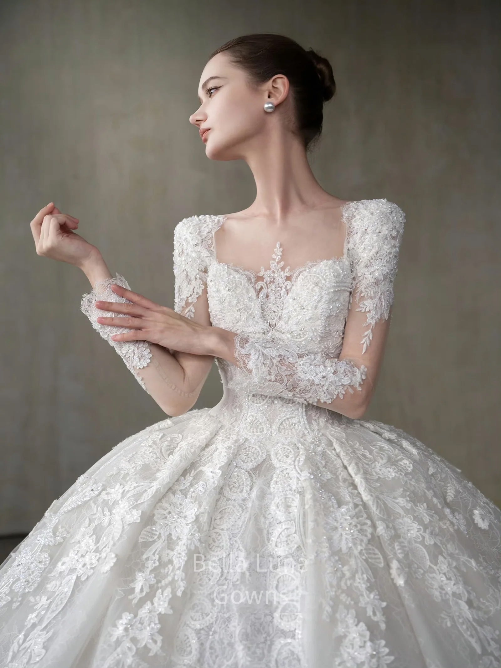 Genevieve off-white square neck lace bridal ball gown with long sleeves, full skirt, and cathedral-style train