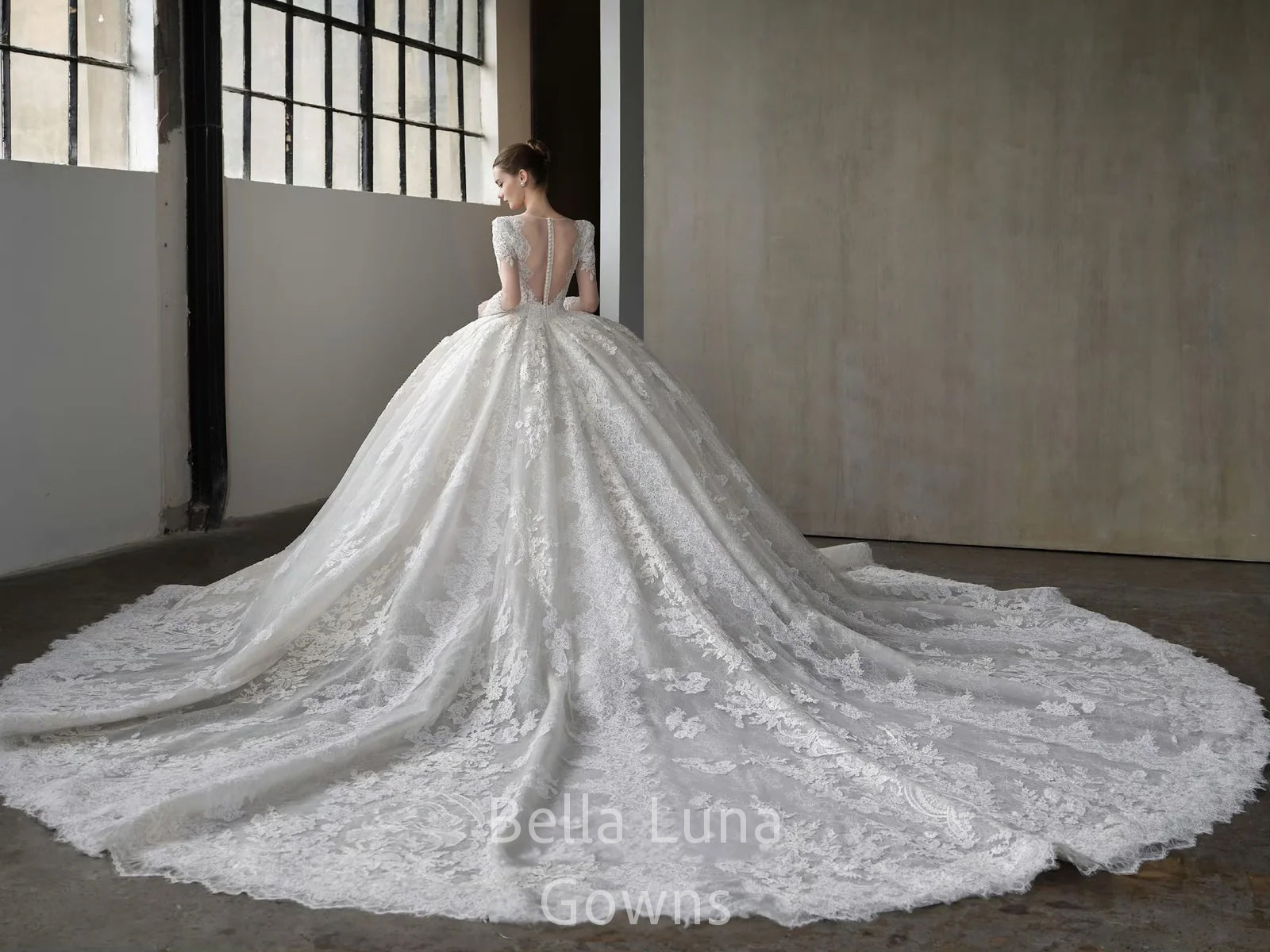 Back view of Genevieve off-white lace bridal ball gown showing lace-up corset back, full skirt, and cathedral-style lace train