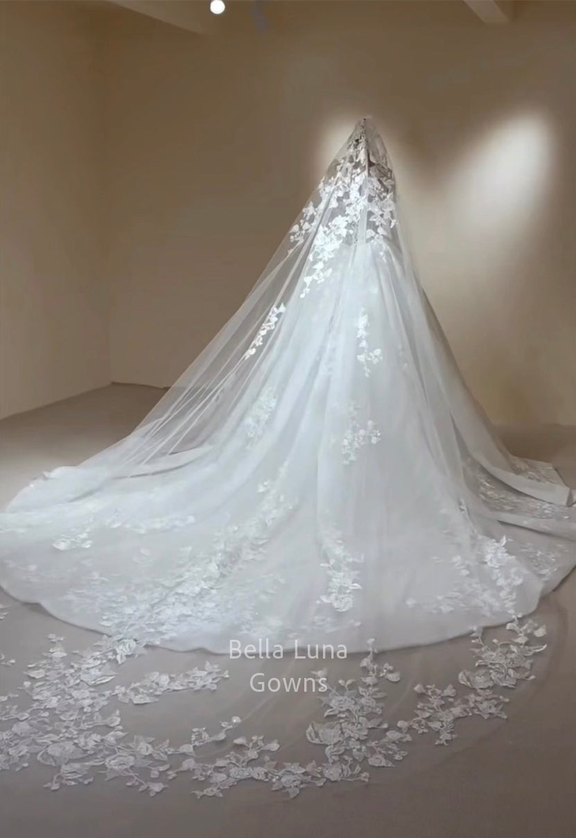 Back view of view of Arabella Shimmer wedding gown showing scalloped floral lace border across the extended train and styled with cathedral veil