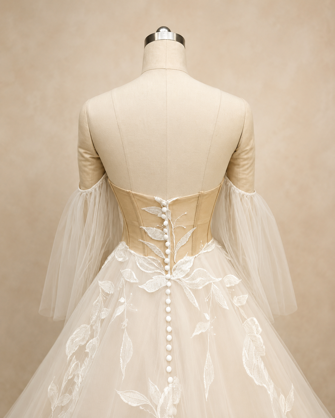 Close back view of Florienne bridal gown showing low back, structured illusion bodice, and button detail