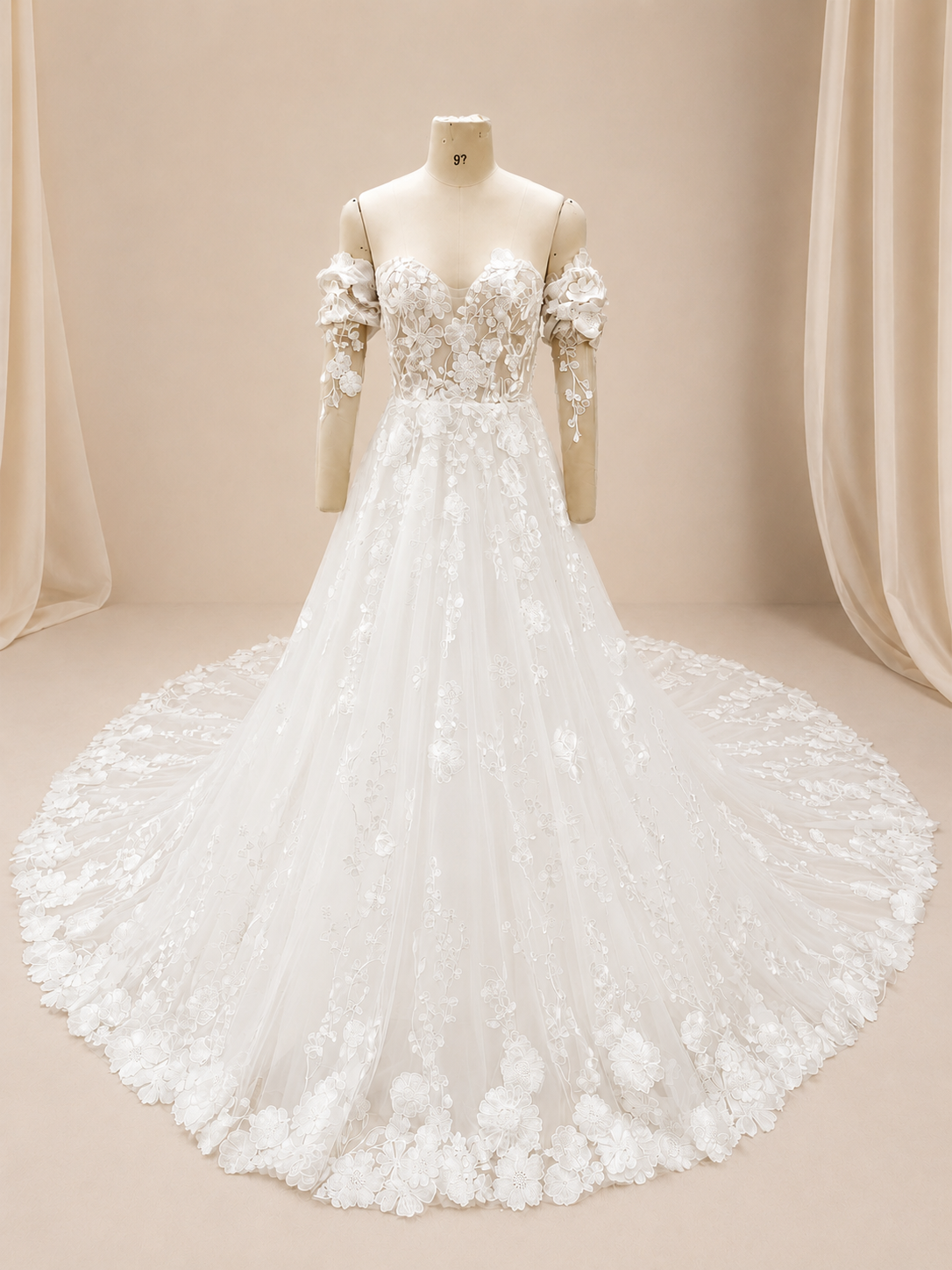 Full front view of an ivory A-line wedding dress on a showroom mannequin with a sweetheart illusion bodice, detachable long sleeves, embroidered floral lace, and a chapel train.