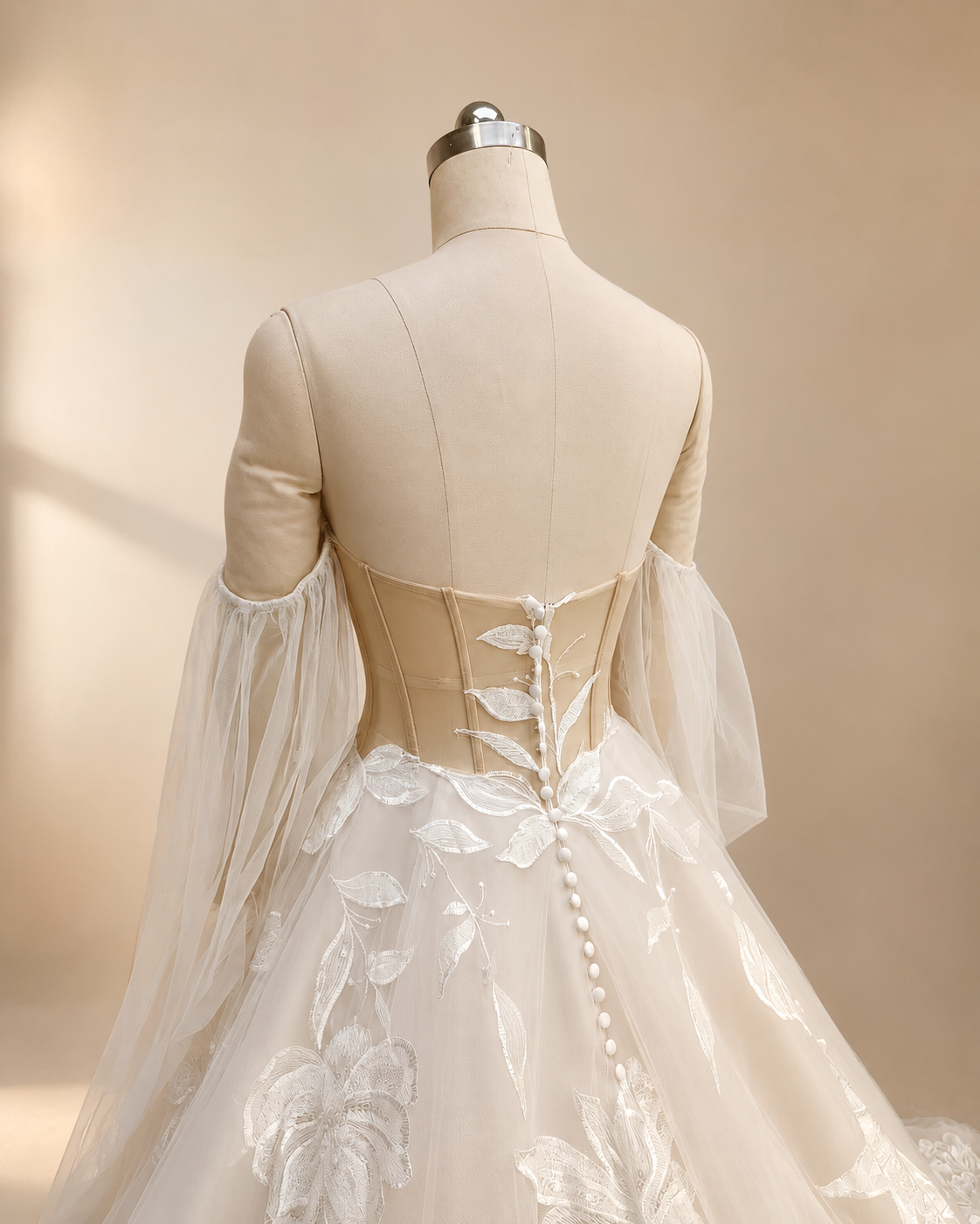 Close back view of Florienne bridal gown showing low back, structured illusion bodice, and button detail