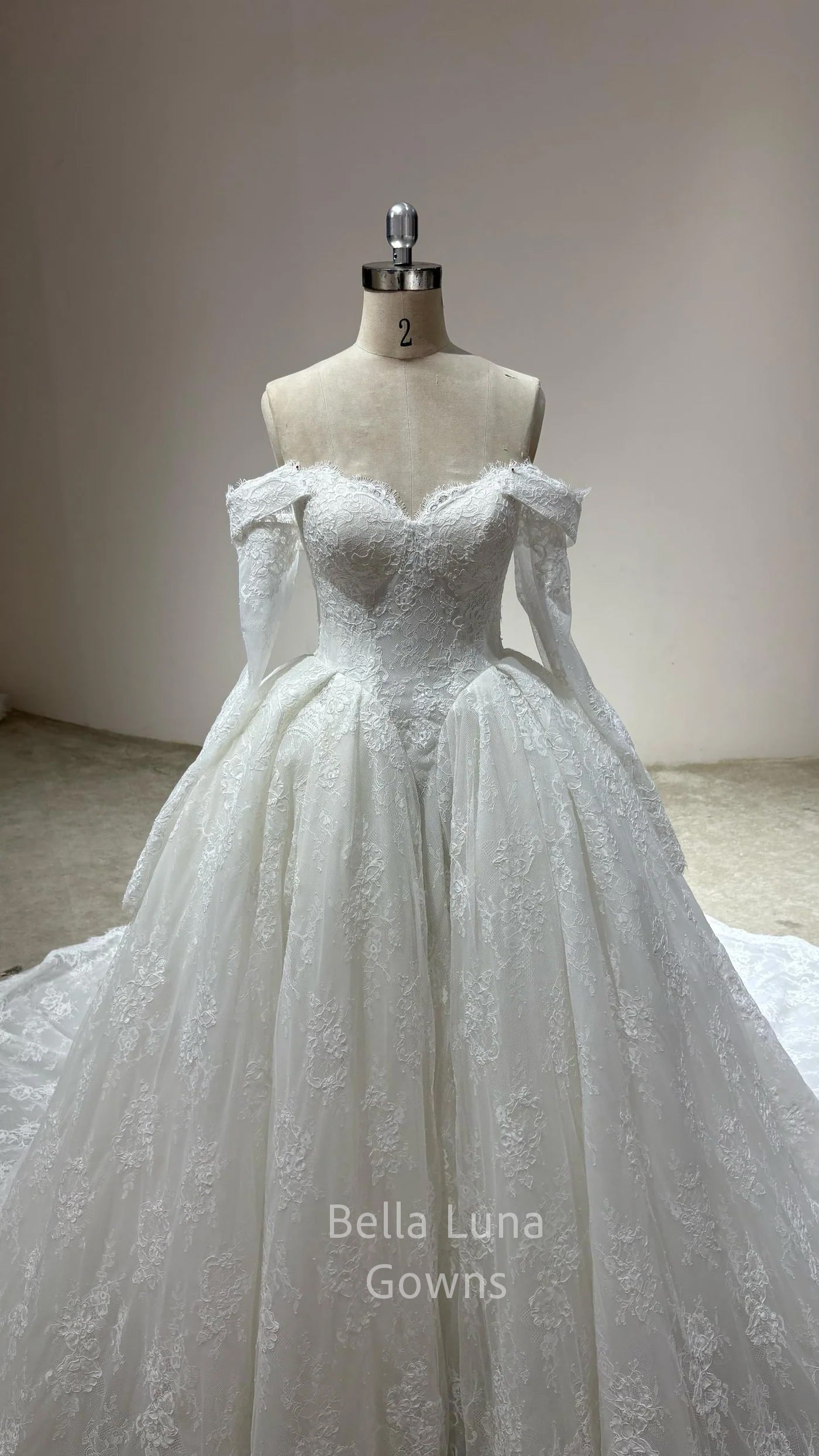 Close-up of Odette corded French lace bridal ball gown styled with optional off-shoulder sleeves and fingerless gloves