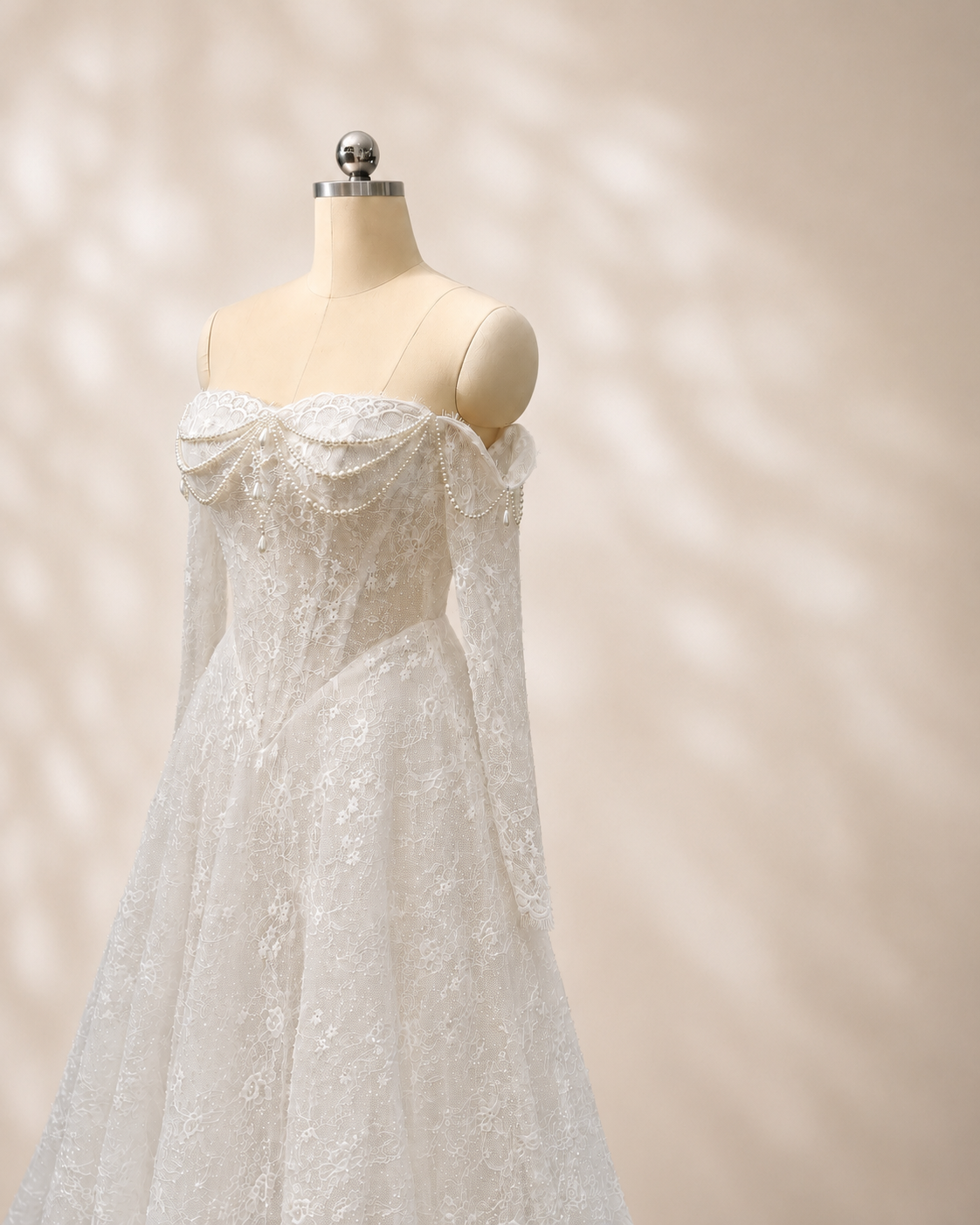 Marielle pearl embellished lace bridal gown angled front view showing structured basque waist and long lace sleeves