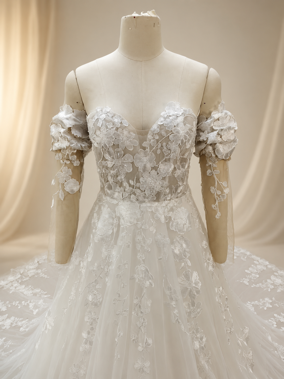 Close-up front view of an ivory bridal gown bodice with a strapless sweetheart neckline, illusion center detail, structured boning, and embroidered floral lace appliqué.
