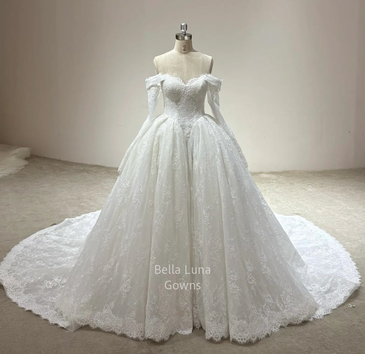 Front view of Odette off-white lace bridal ball gown with sweetheart neckline, full skirt, optional sleeves