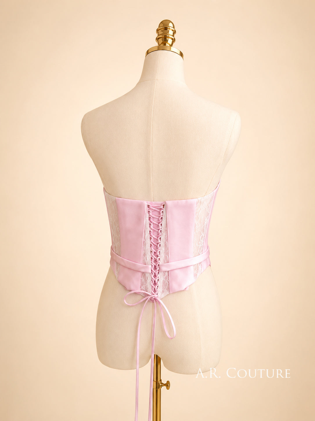 The Blush Reverie pink satin and lace bridal corset top on mannequin back view with pleated sweetheart neckline