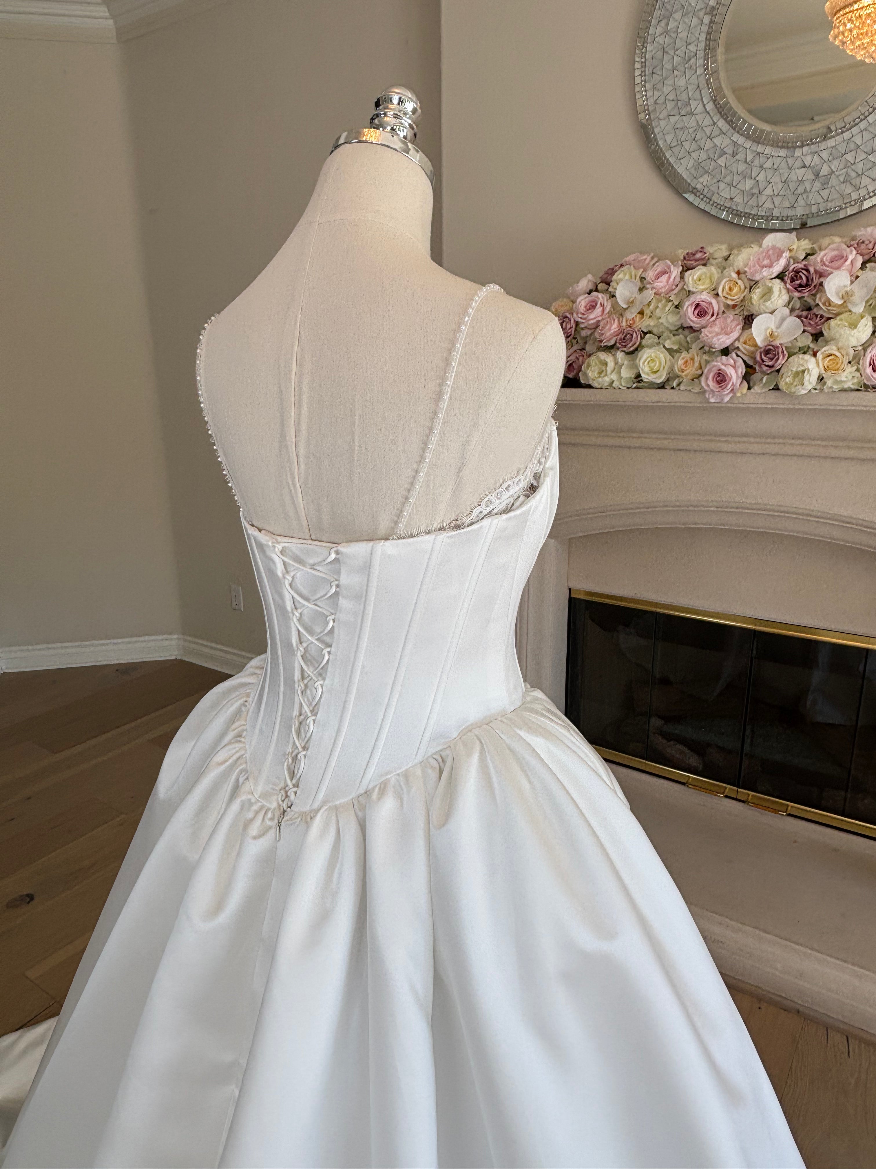Close-up back view of Amélie convertable french lace wedding dress with Satin Mikado Corset and overskirt. 

