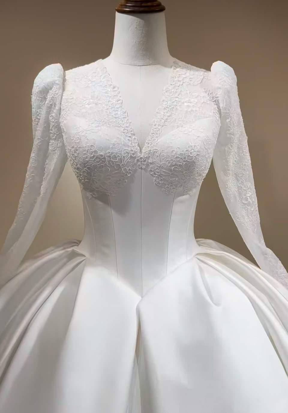 Close-up of Victoria sweetheart Mikado bodice beneath a French lace V-neckline and long lace sleeves