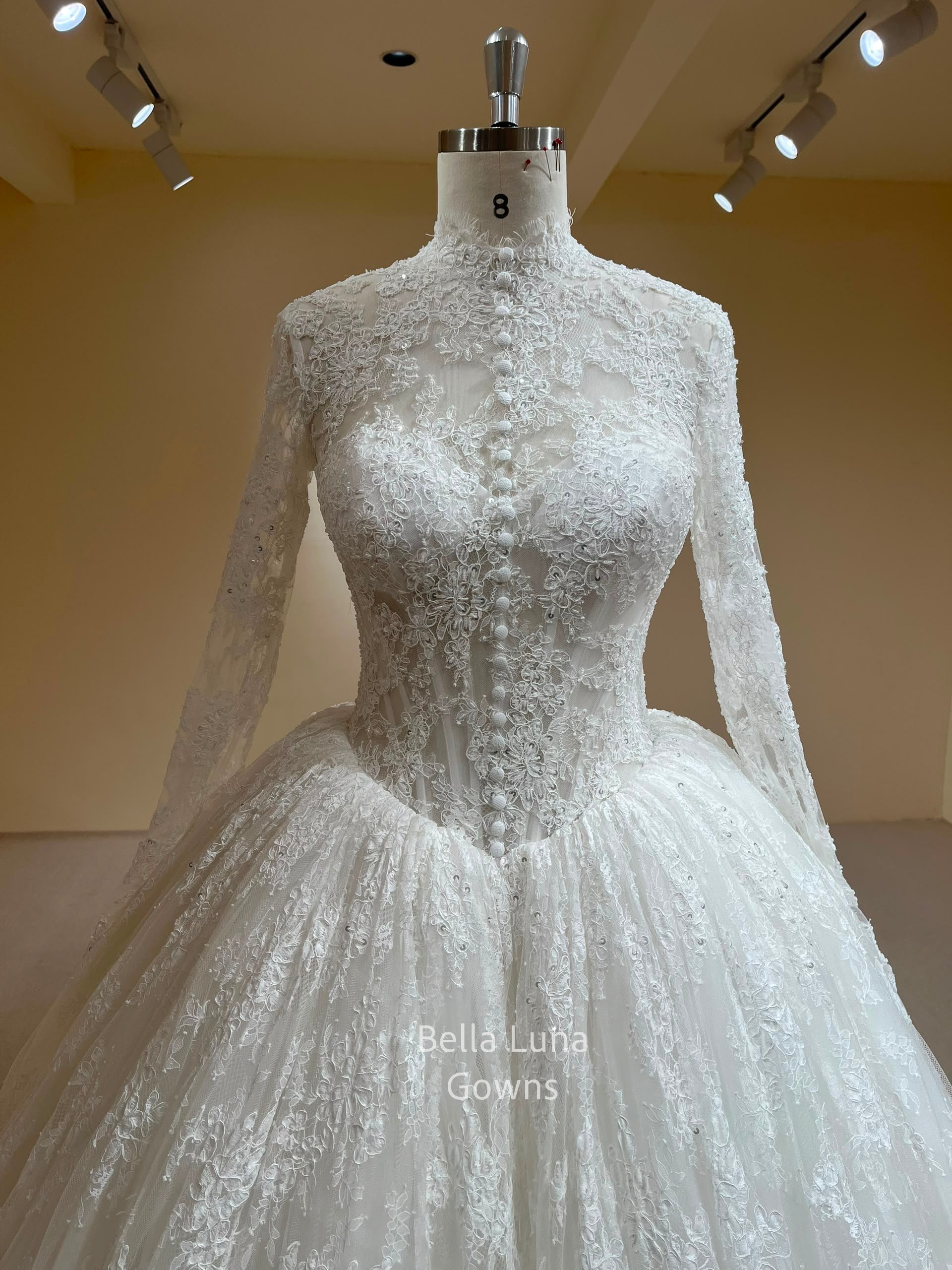 Close-up of the Theodora high-neck corded French lace wedding dress with hand-beaded bodice and center-front covered buttons